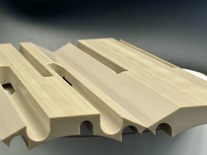 deux pièces en peek usinées avec fentes et perçages verticaux