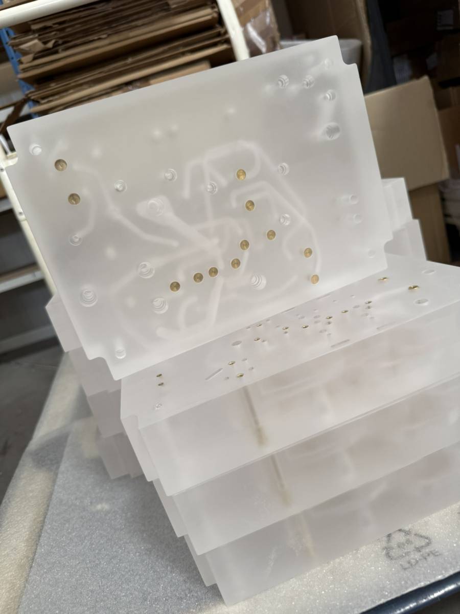 circuits gravés pneumatiques translucides empilés sur table d’atelier pour un client situé à nice