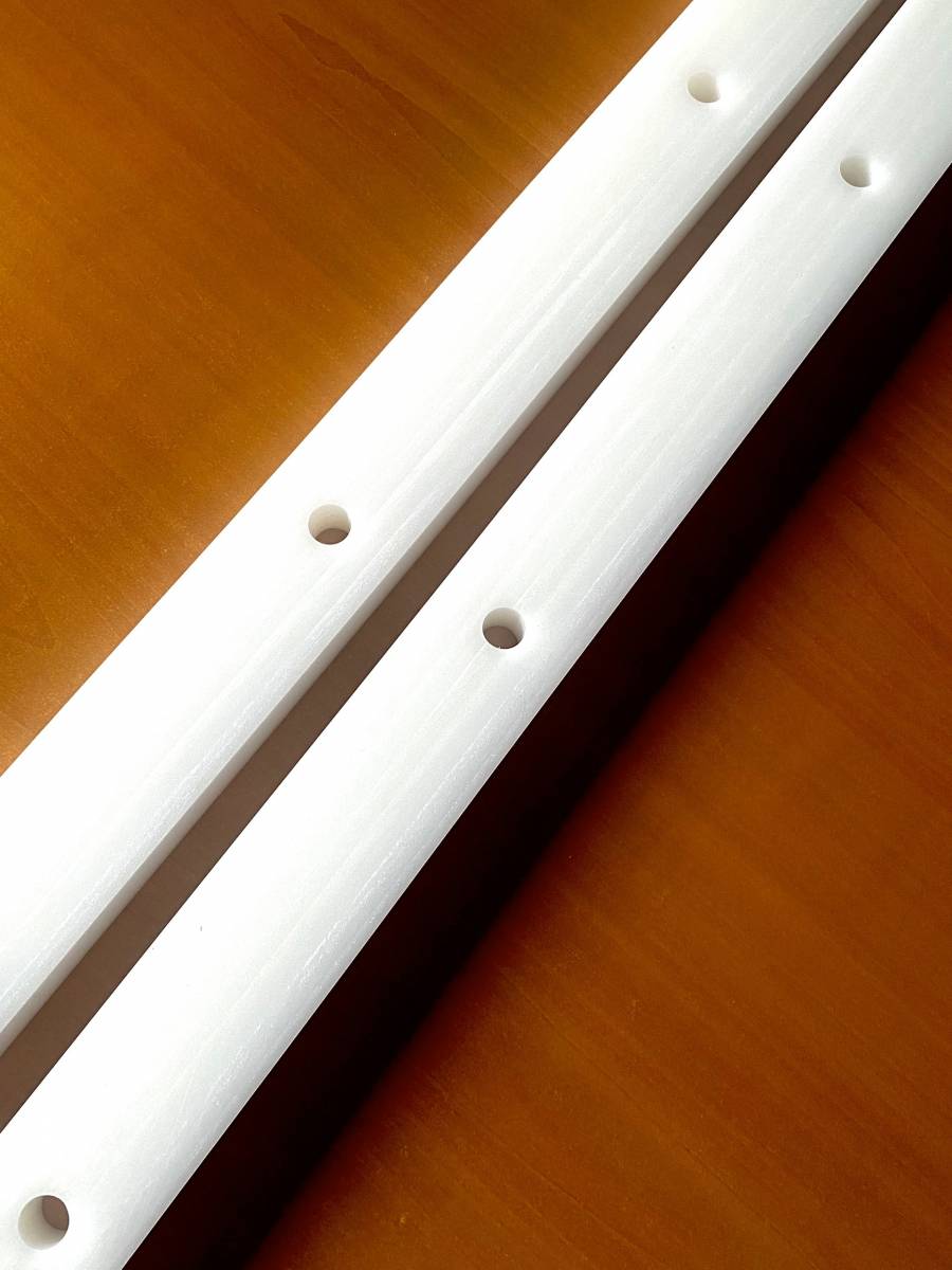 deux barres en PEHD 500 usinées sur mesure par ACA Plastiques, avec des trous parfaitement alignés et une surface de haute qualité, adaptées aux projets industriels.